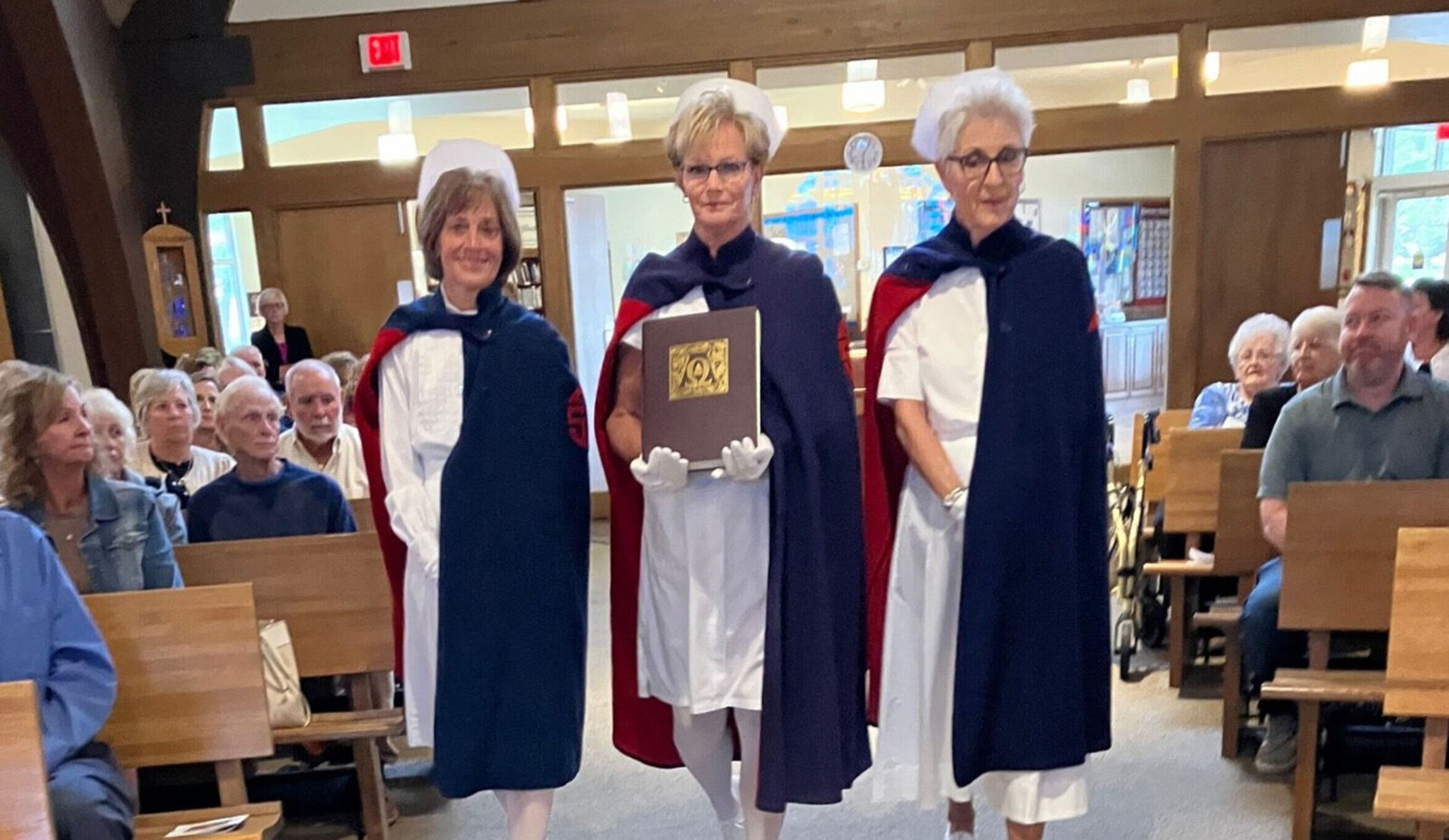 3 nurses holding book